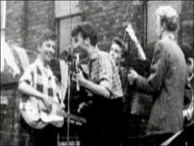 John Lennon e os colegas tocando.