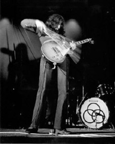 Jimmy Page tocando guitarra com um arco de violino.